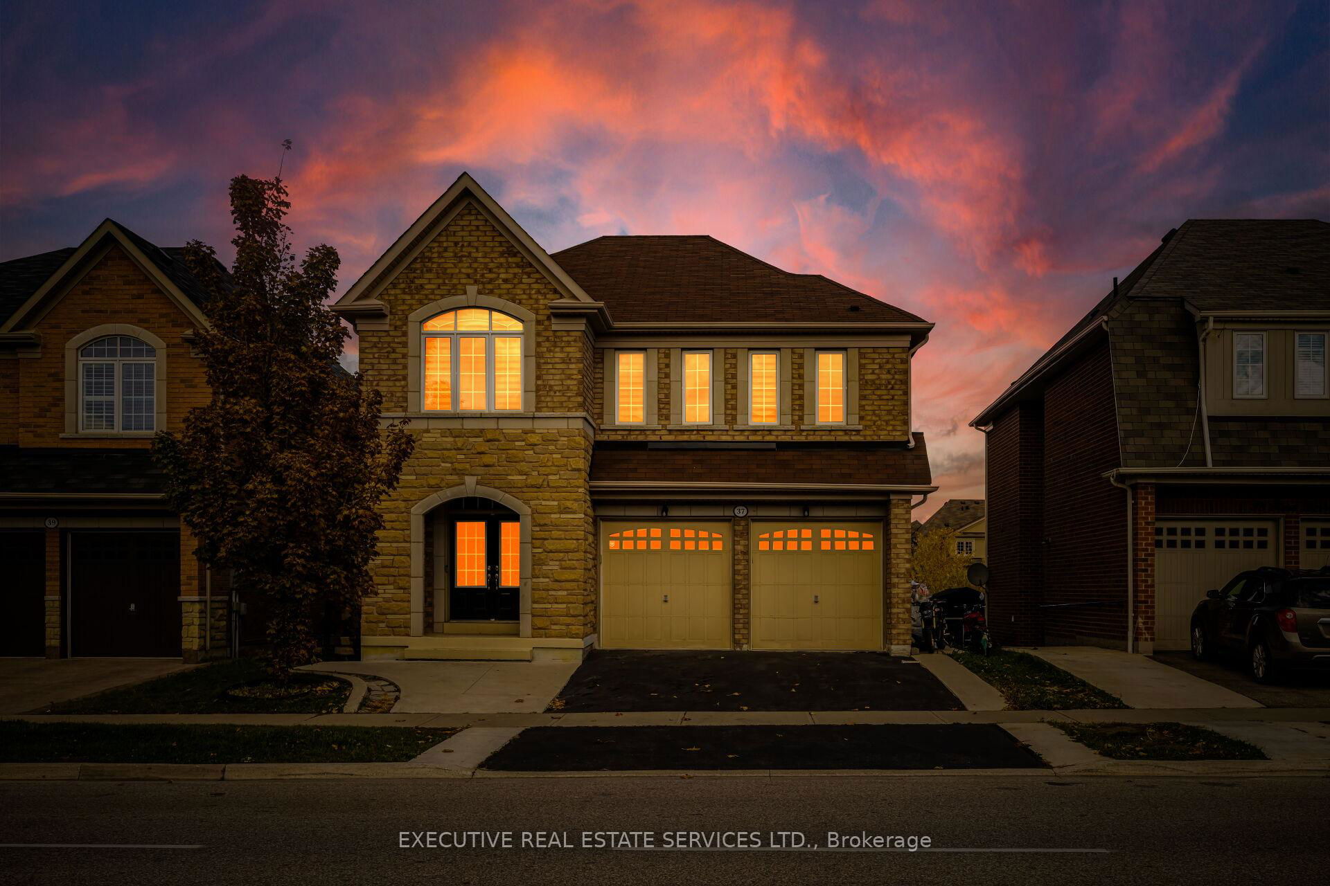 Modern detached home in Brampton at sunset with For Sale sign